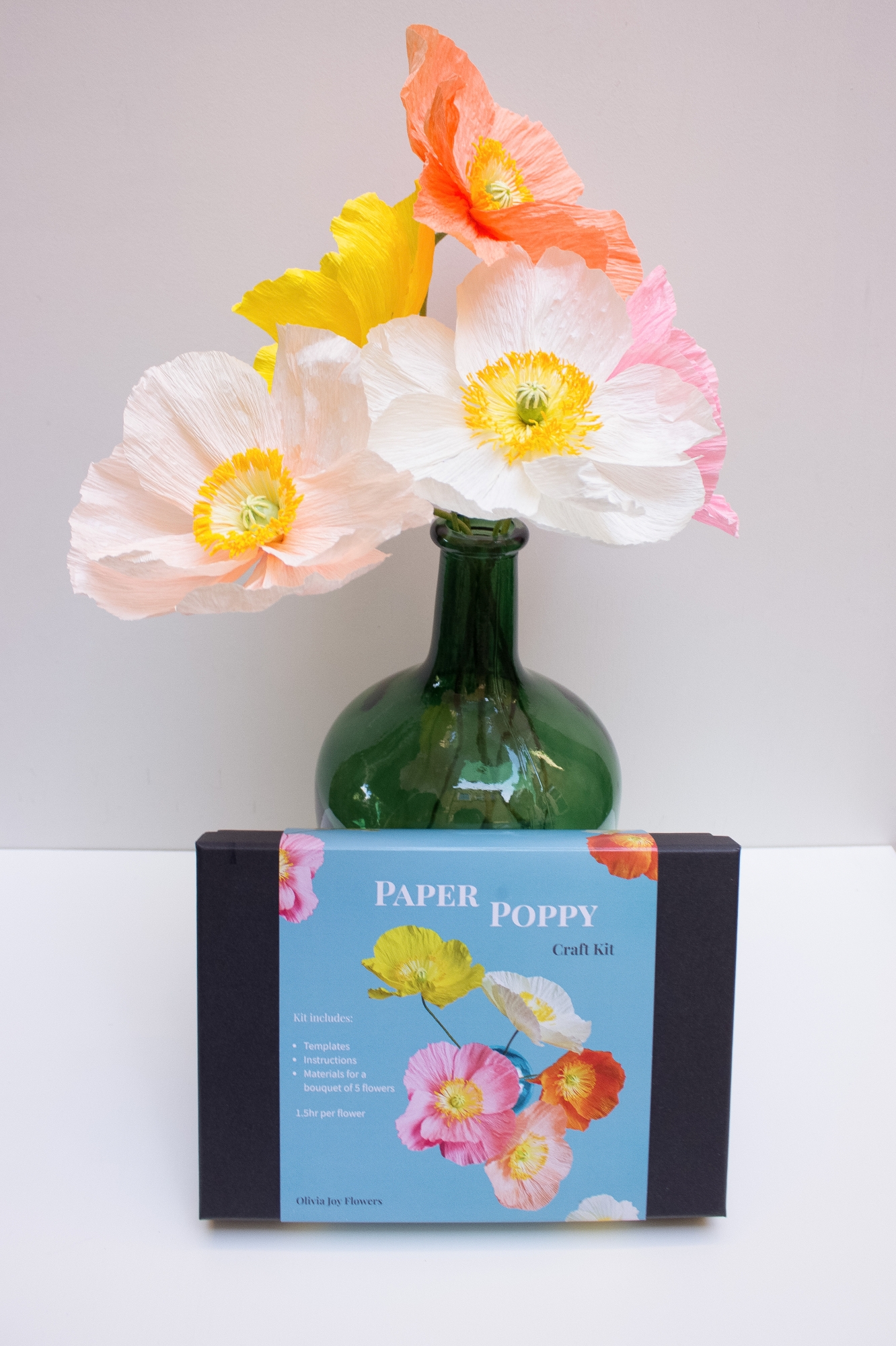paper poppies in a vase, with a craft kit in front