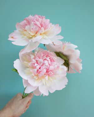 three paper peonies in pink, white and cream held in a bunch